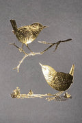 Two metallic birds on branches against a gray background